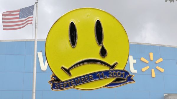 Illustration features yellow pin with frowning face and a tear, and the text September 11, 2001. The background is a Walmart storefront with an American flag flying in the air.